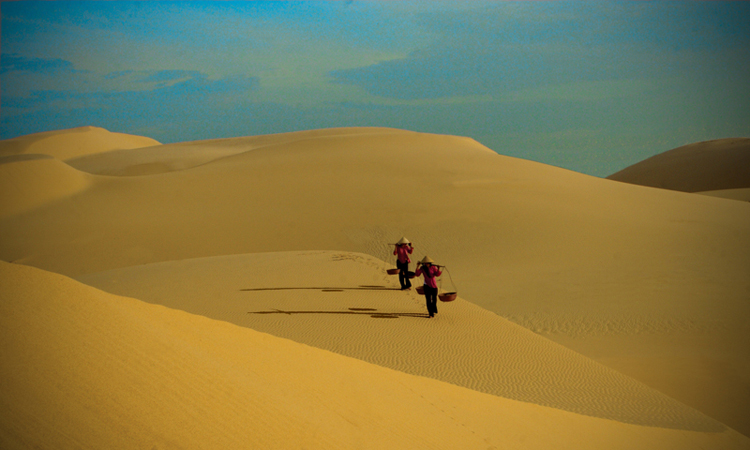 Ảnh 2 cô gái gánh hàng qua bãi cát vàng